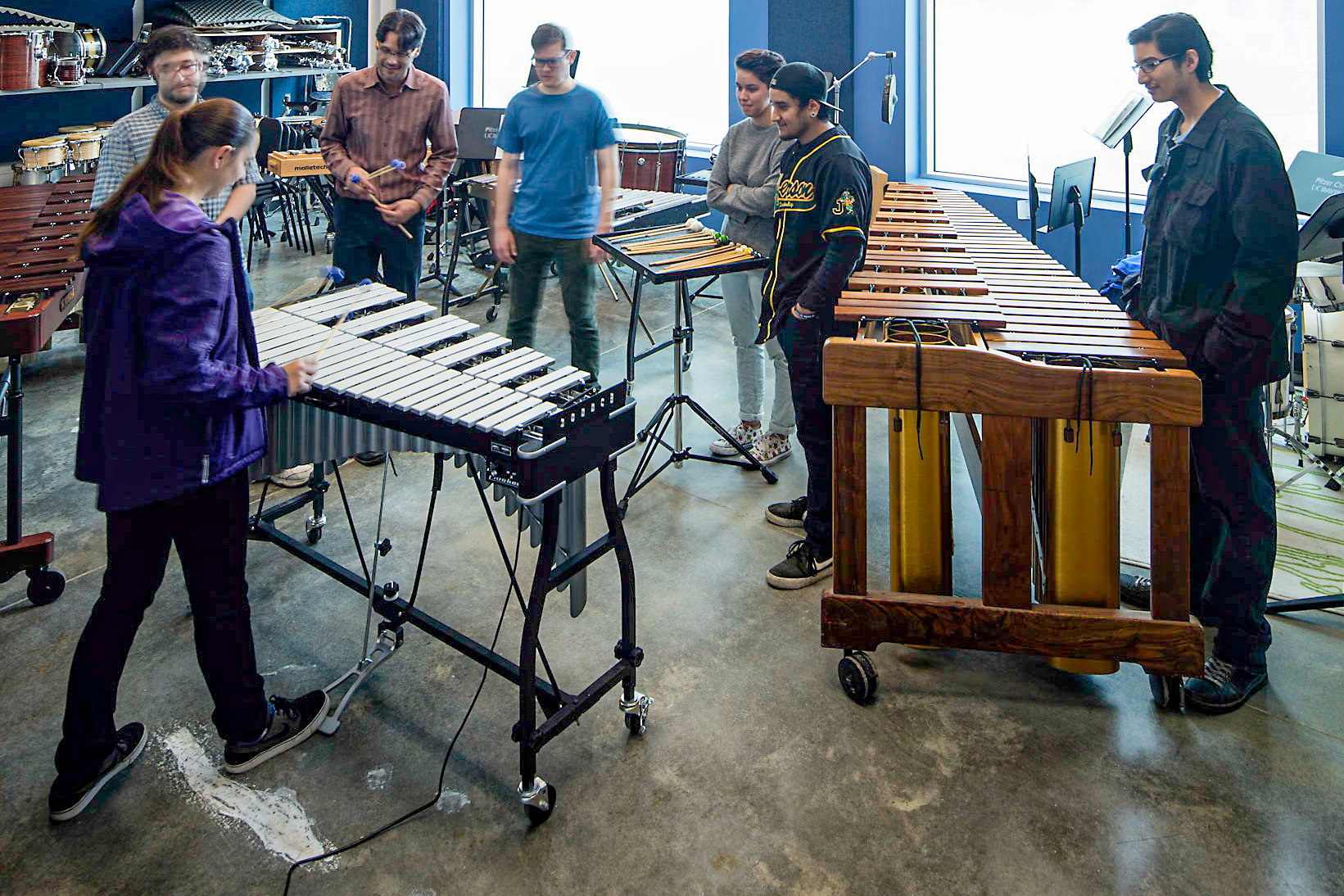 High school students rehearsing on marimbas and vibraphone in a music classroom
