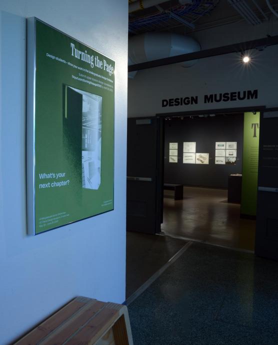 Design Museum entrance interior with green wall poster, bench and dimly lit display cases