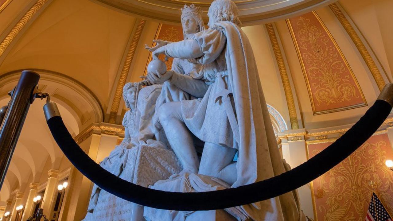 A public statue cordoned off with rope inside a domed rotunda, related to debates over monument removal.