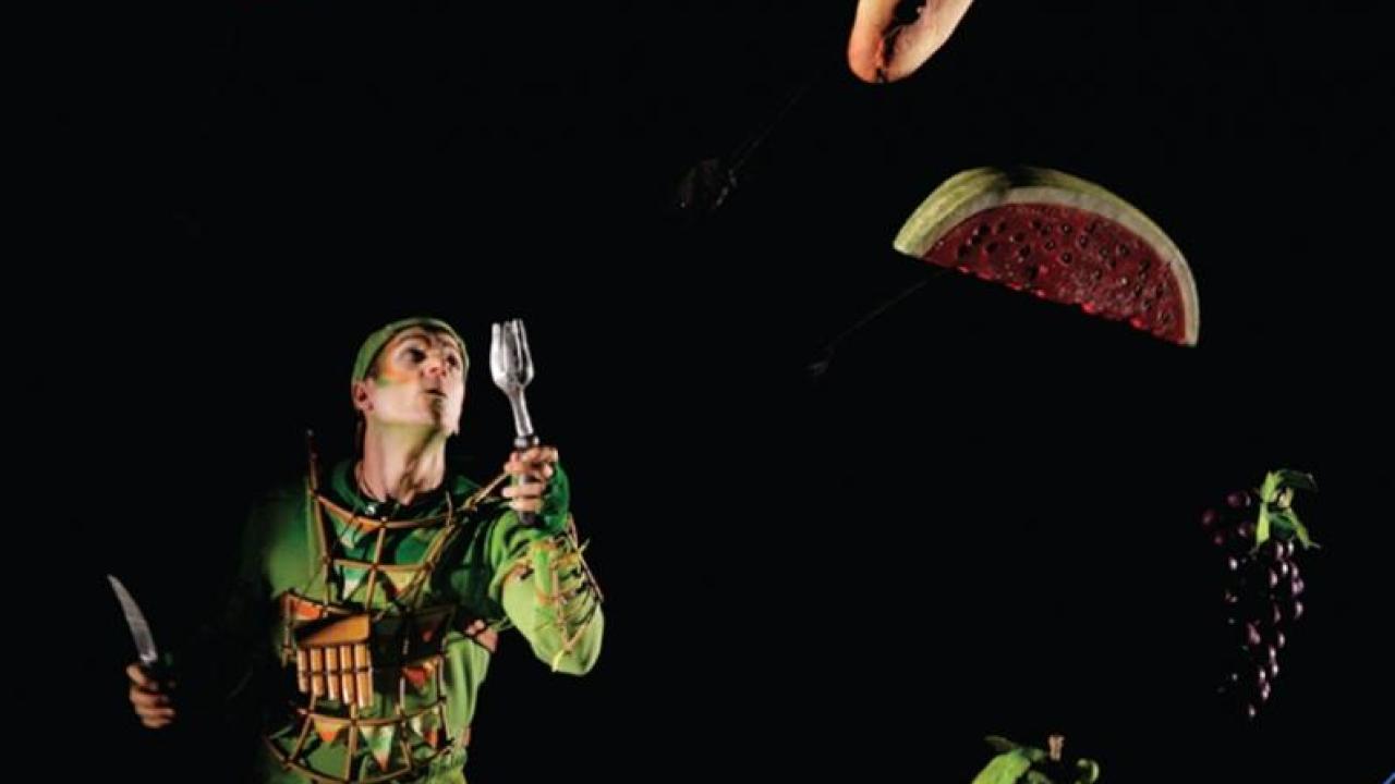 Dark book cover illustration of a figure in tattered clothing juggling food items, for "Feasting and Fasting in Opera."