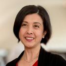 Portrait of smiling woman with short dark hair, red top and black cardigan