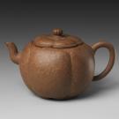 A brown teapot in the Shape of a Plum Blossom.