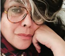 Woman with glasses staring into the camera